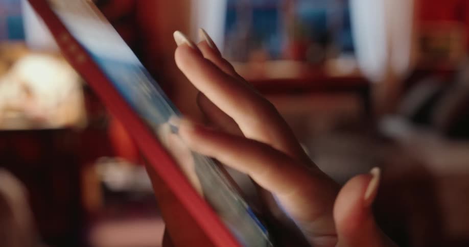 A woman is typing on her tablet