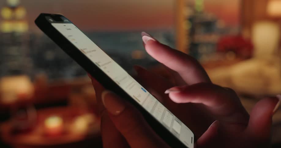 The fingers of a human hand toching the bright screen of a mobile phone