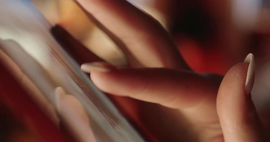 A woman is scrolling photos on her phone
