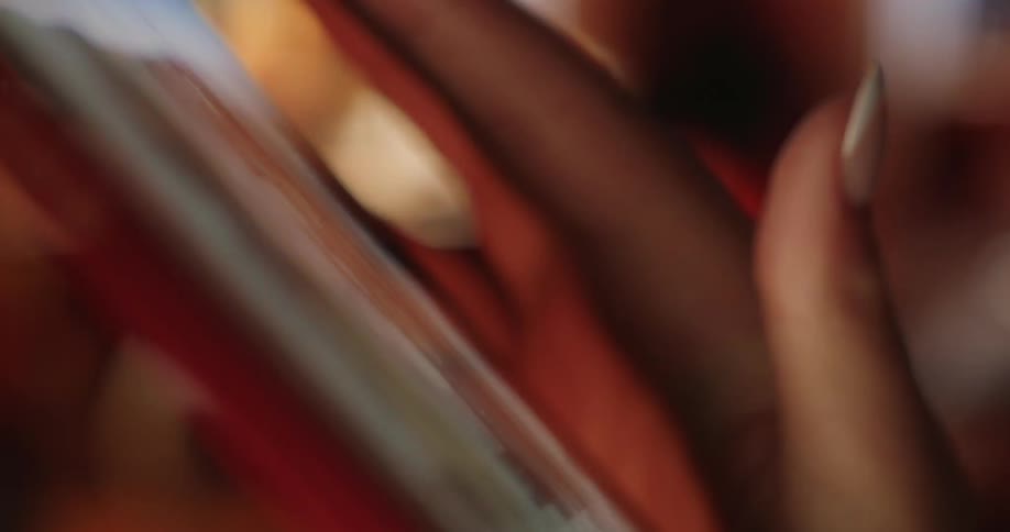 Human fingers with long nails scrolling down a cell phone screen