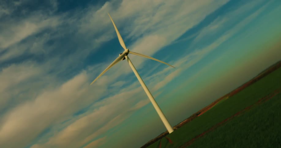 A wind turbine stands tall against a blue sky with wispy clouds