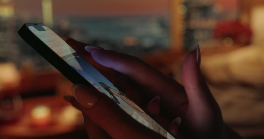 Human fingers scrolling down on a smartphone screen with lots of images