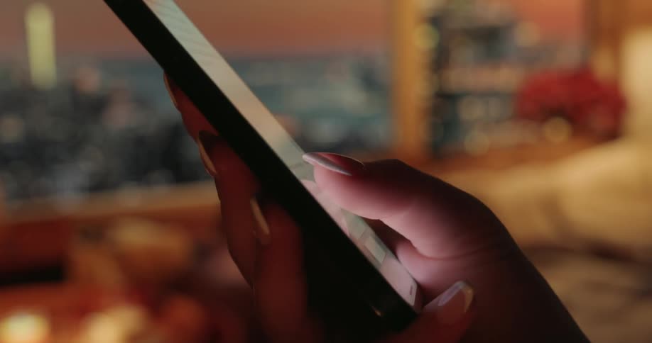 A woman types on the phone with her thumb