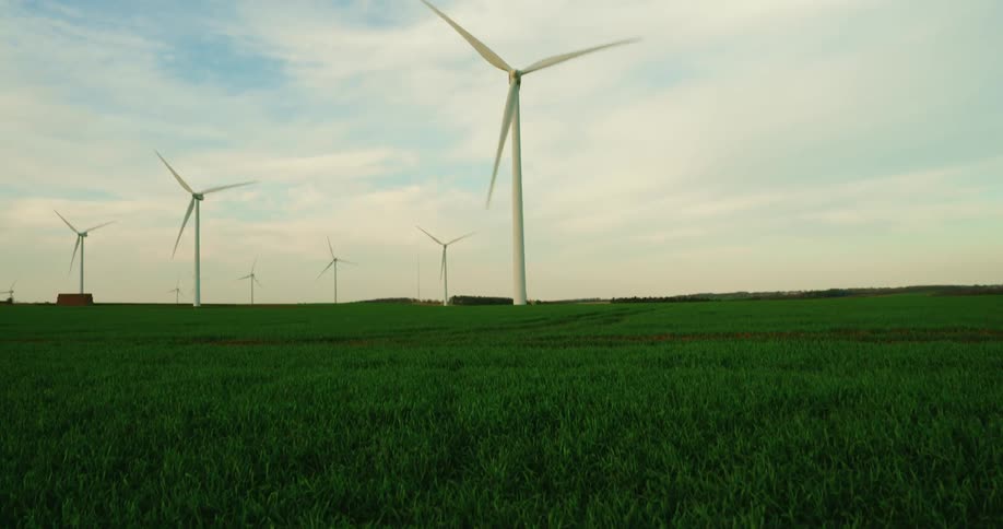 Many windmills turn on the green grass