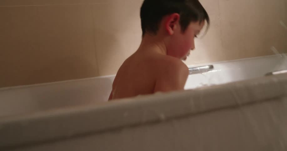 A child splashes water in the bathtub
