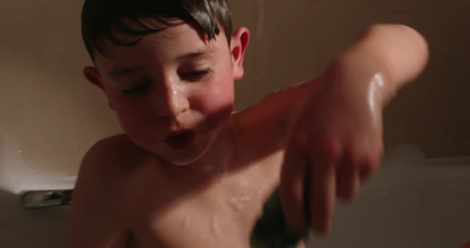 A child is playing with a toy in a bubble bath