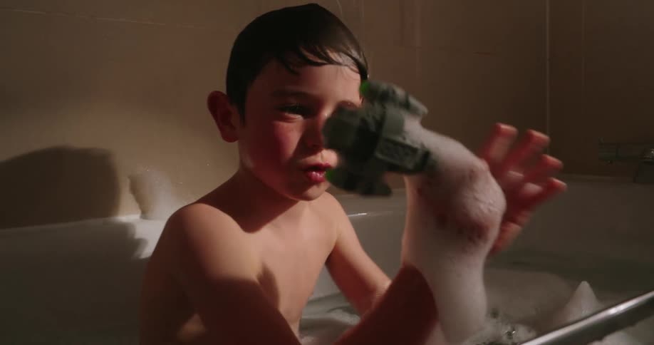 Child playing with a toy inside a bathtub all soapy
