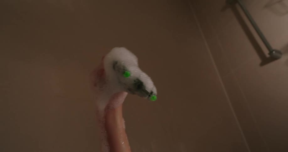 Boy playing with a toy in a bathtub with foam