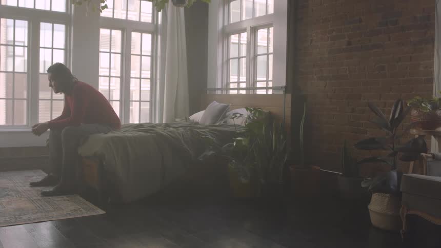 A footage of a person sitting on the bed