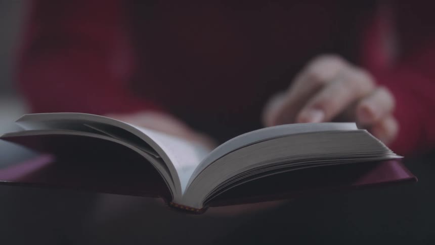 A person turns the pages of a book