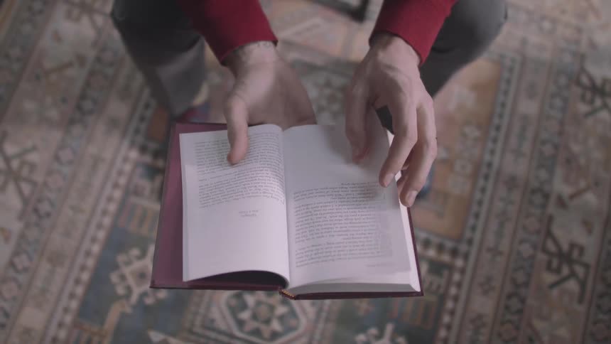 A woman is flipping the pages of a book
