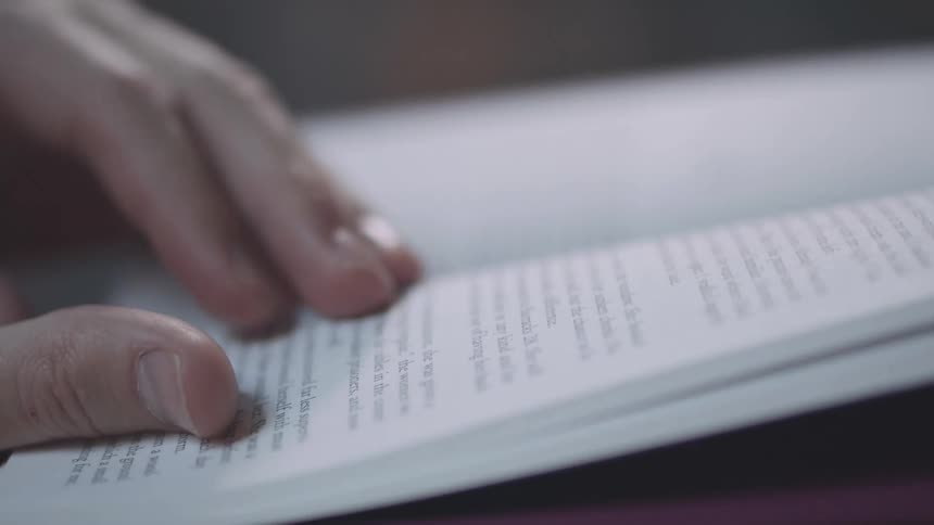 A person turns the pages of a book