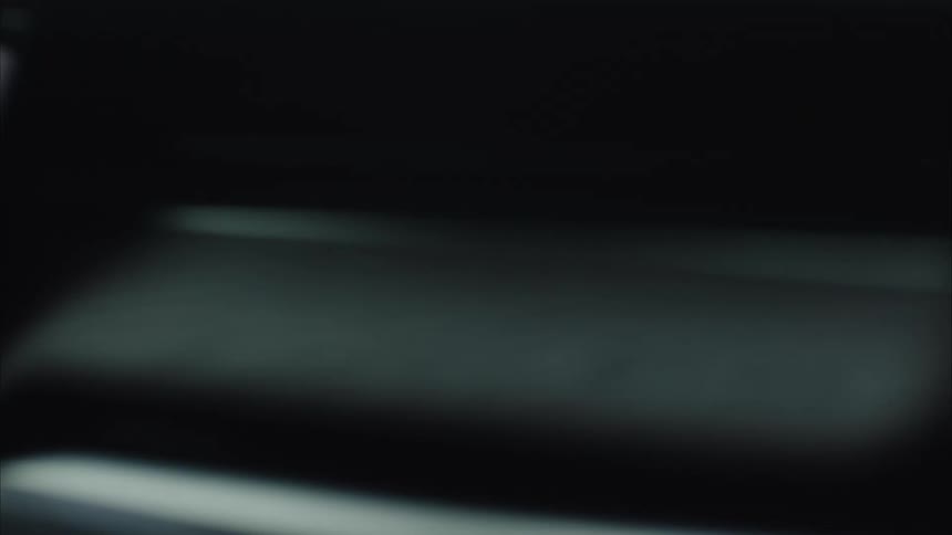 The rivian logo illuminated on a dark seat inside a vehicle