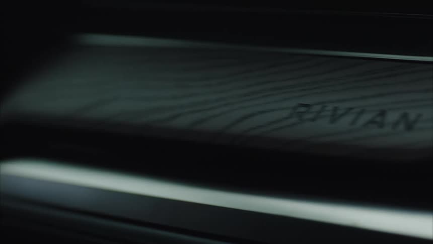 Person grips the steering wheel of an electric vehicle manufactured by rivian