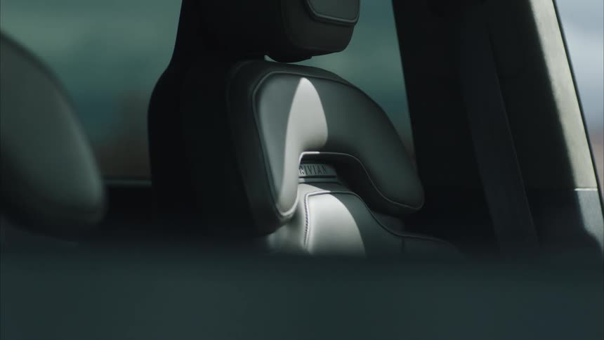 Seat of a car with then framing of a man outside on a mountain landscape