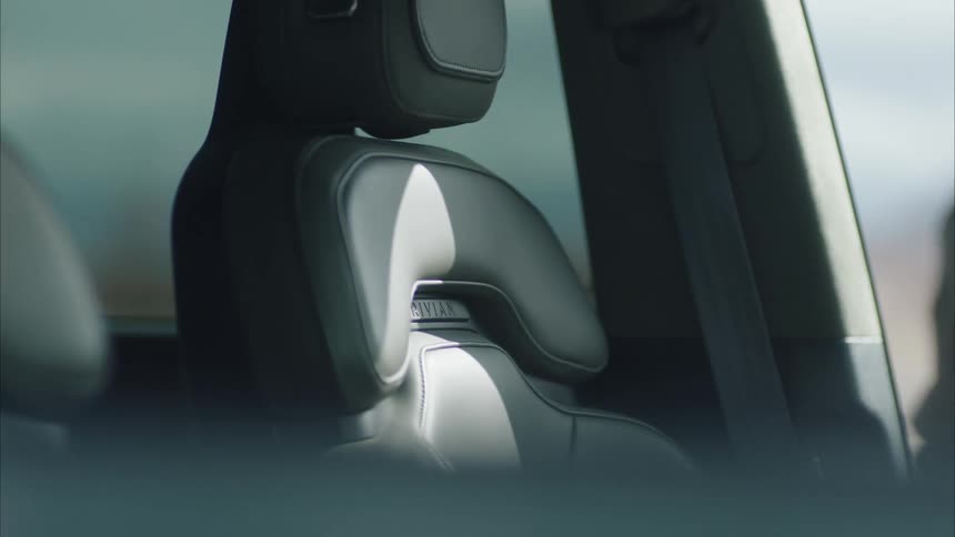 The back of a drivers side car seat shows textured details as a man steps out of the vehicle