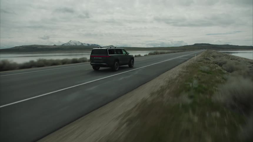 A sports utility vehicle drives on the road on a cloudy day