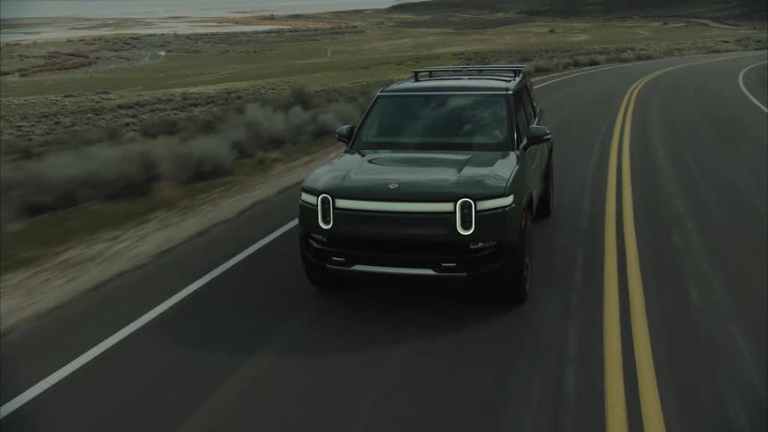A vehicle is traveling on the winding road by the mountains