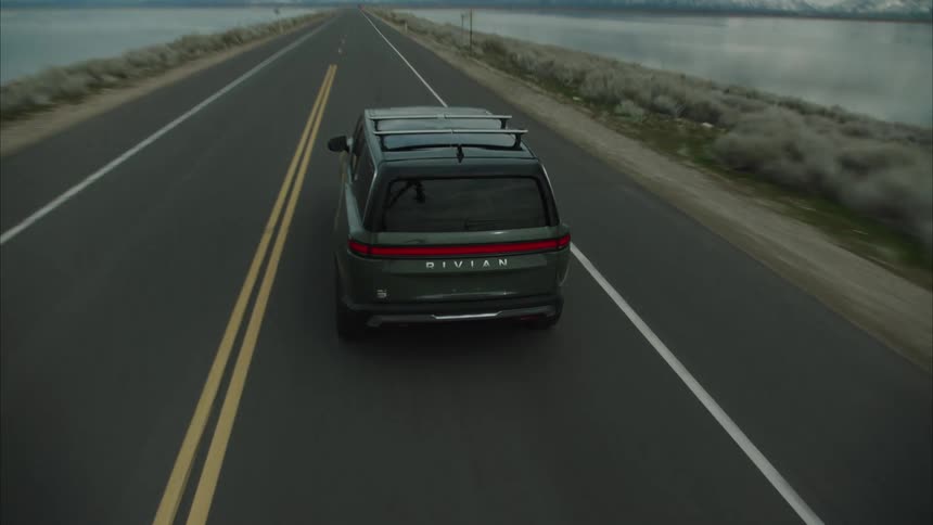 The vehicle is driving on a long road towards a mountain