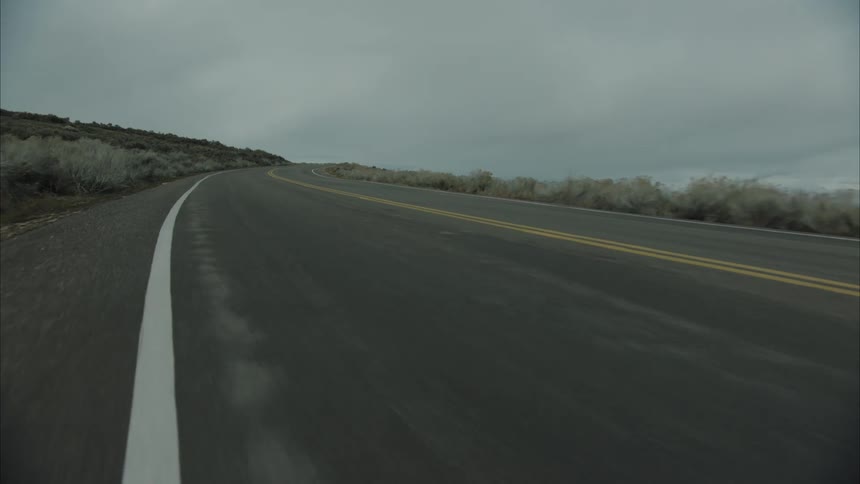 Suv vehicle traveling along a wide road in a natural area