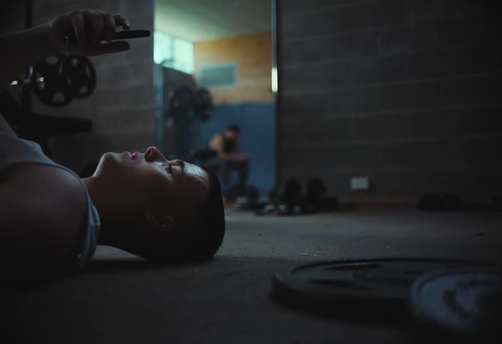A footage of a person laying on the floor and operating a smartphone