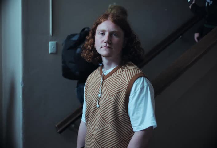 Portrait of a teenage student and in the background students going up and down the stairs