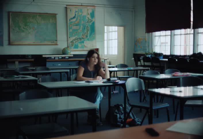 Classroom a young woman is focused on her task while other people get up and leave the room
