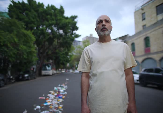 A clip of a man holding a trash bag