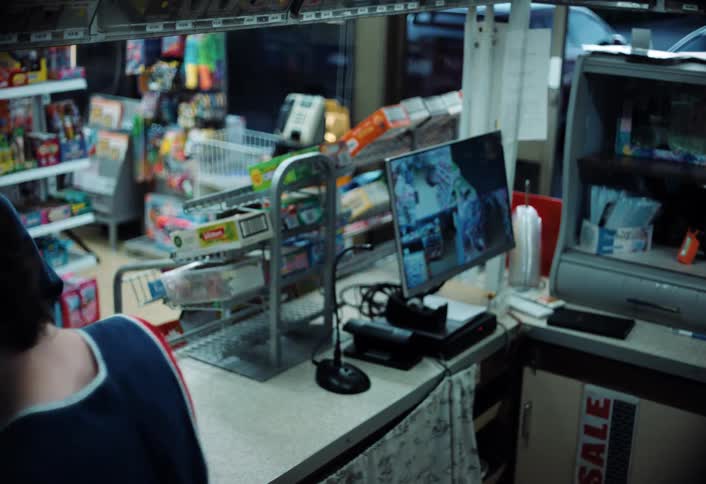 A store clerk accepts cash from a customer purchasing a gallon of milk in a convenience store