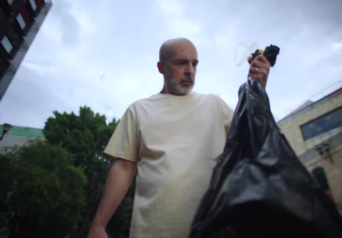 A footage of a man running with trash in the neighborhood