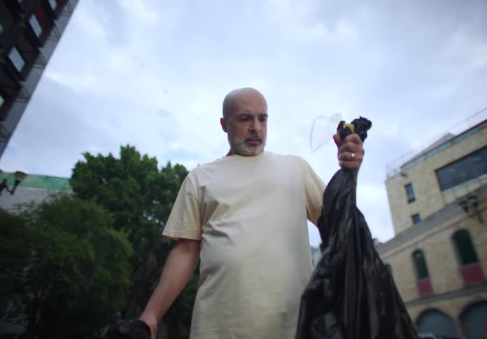 A footage of a man yelling with a trash bag