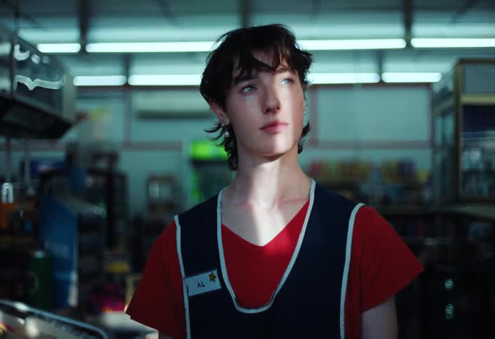 A worker is staring into the distance as he stands in a store