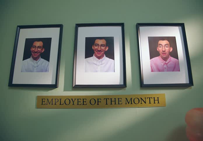 Three photographs of the same person on the wall