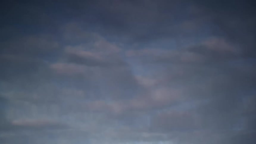 In a softly shifting reflection the waters surface mirrors the blue sky and scattered clouds above forming gentle ripples that slightly distort the view capturing a calm overhead scene