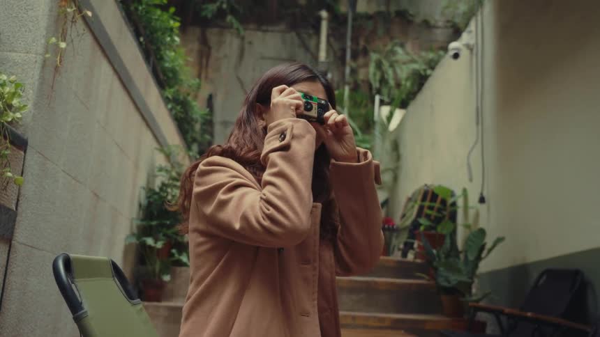 Girl taking a picture with an old camera and is happy