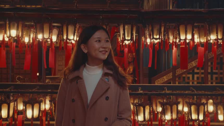An asian woman is admiring the chinese lamp decorations in a restaurant