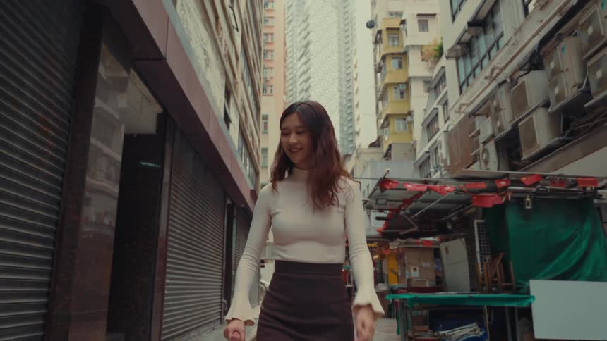 A woman is smiling as she walks through the alley