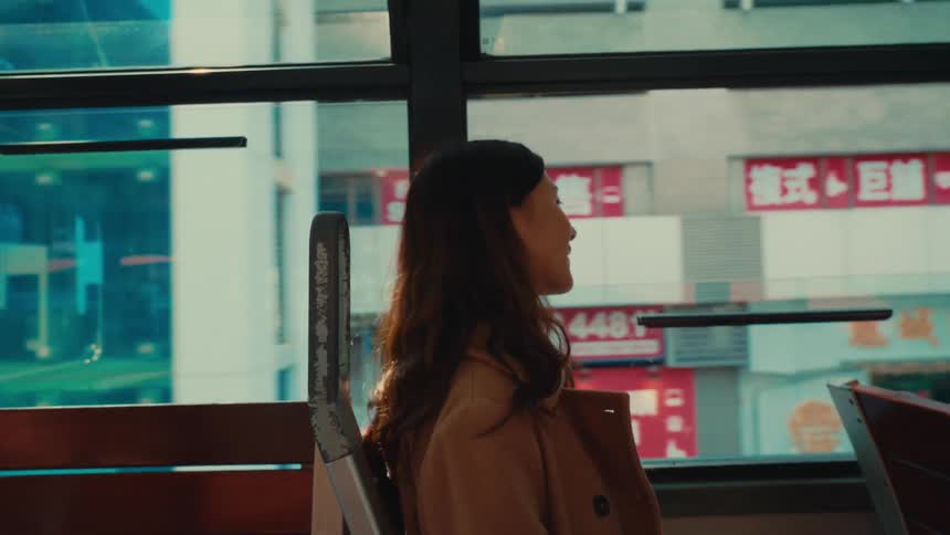 Woman inside a bus moving through the city