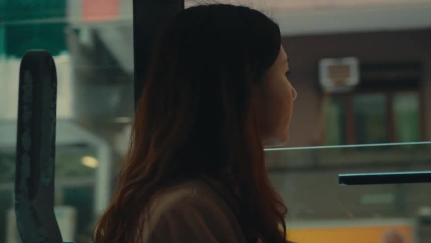 A woman is riding the bus in the city