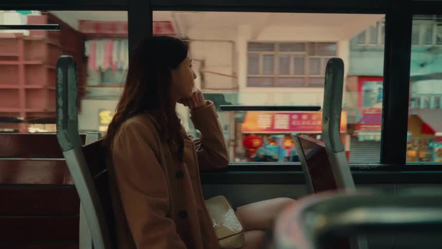 Woman sitting inside a bus moving through the city