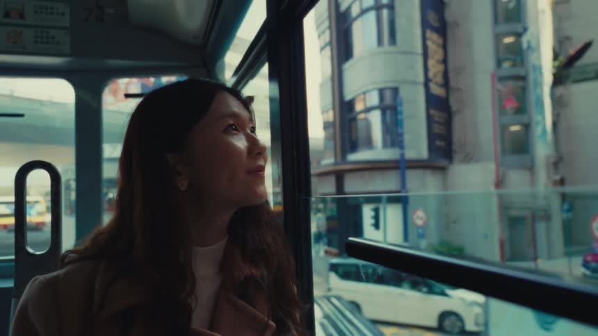 Girl looking out of a bus window and smiling