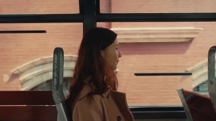 A woman is riding a bus in the city
