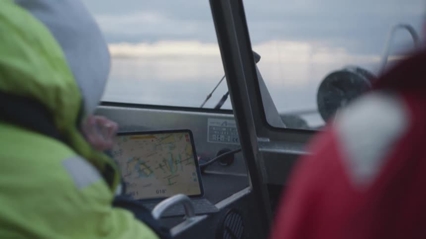 People are looking at a map on the tablet as they travel by boat