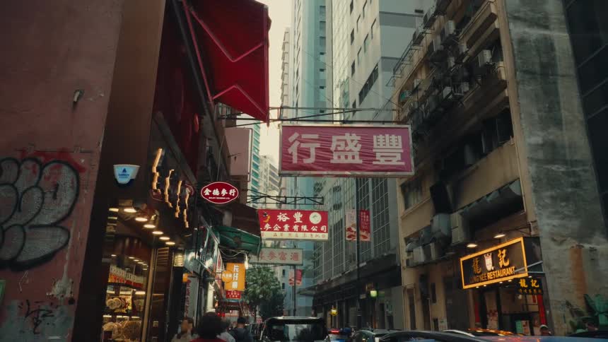 A vibrant crowded hong kong street bustling with people walking in a commercial district filled with many low hanging various commercial signage displaying chinese text