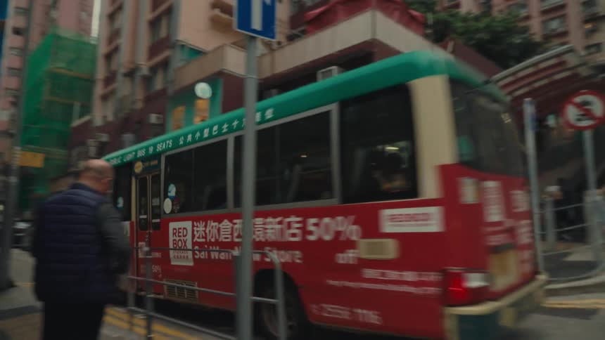 The bus passes the pedestrians in the city