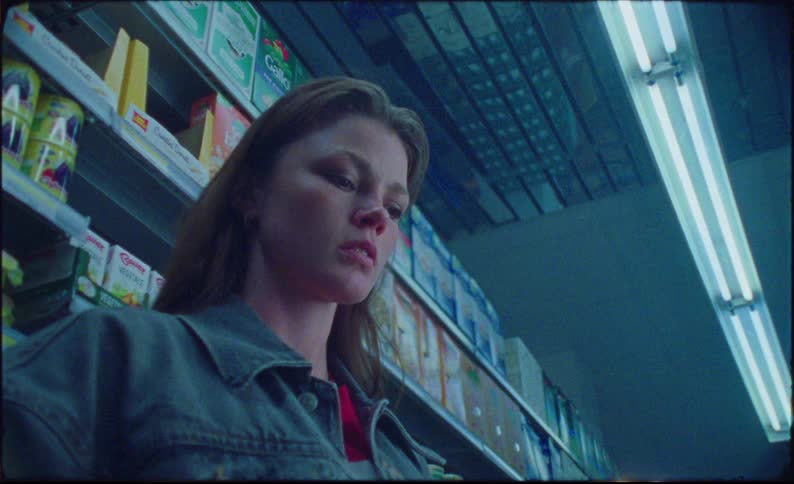 Girl inside a supermarket looking down a little scared