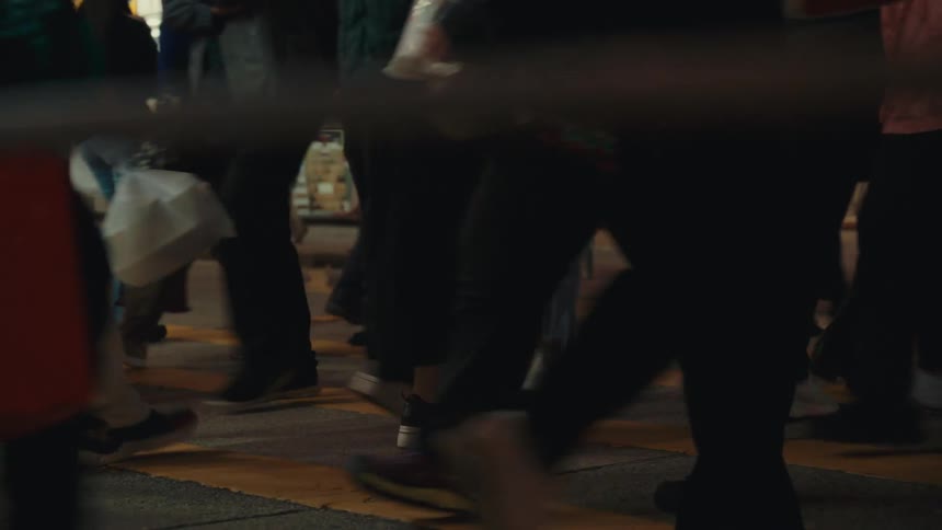 Pedestrians crossing the street on the crosswalk in front of a busy store