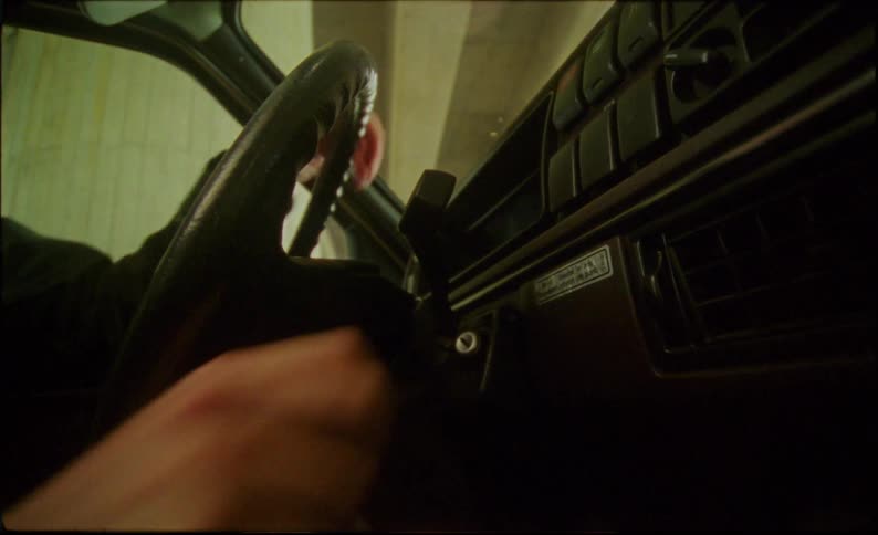 A man gets in the car and starts it with a key