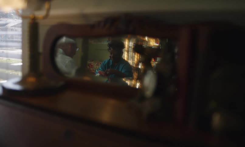 Small mirror reflects two people playing cards