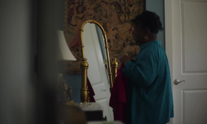 Woman in front of the mirror looking at a pink outfit